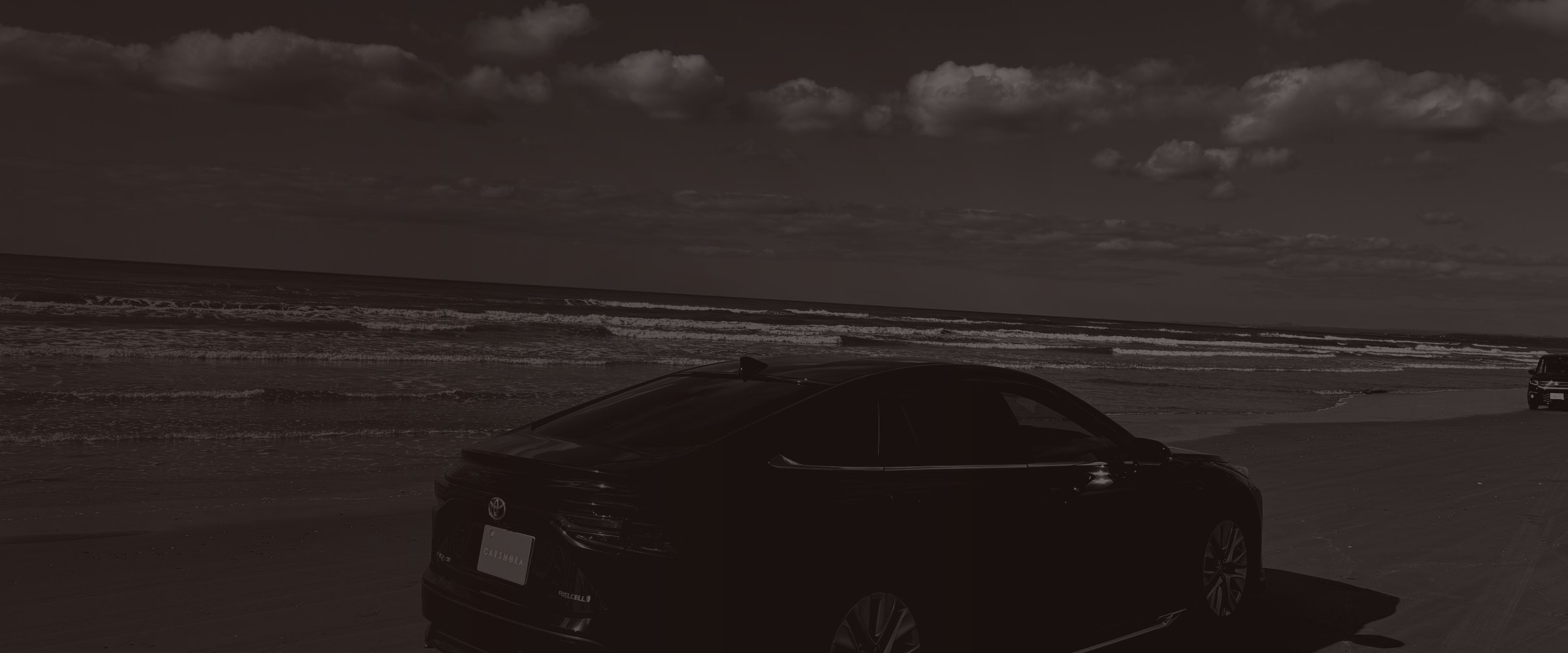 海辺に停まるCARSMORAの取材車